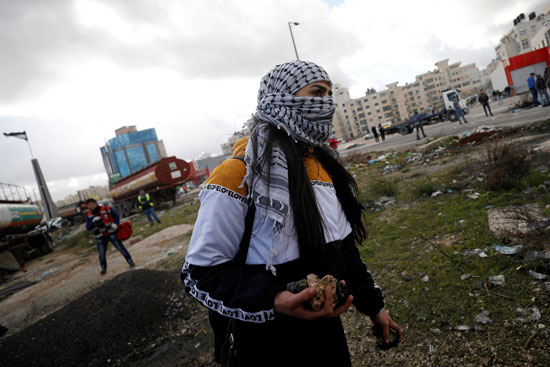 فتاة فلسطينية تحمل الحجارة