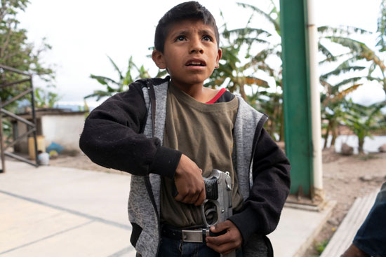 طفل مكسيكى يحمل مسدسا حقيقيا