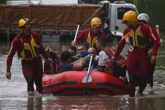 رجال الاطفاء ينقذون الناس في شارع غمرته المياه في ساو باولو