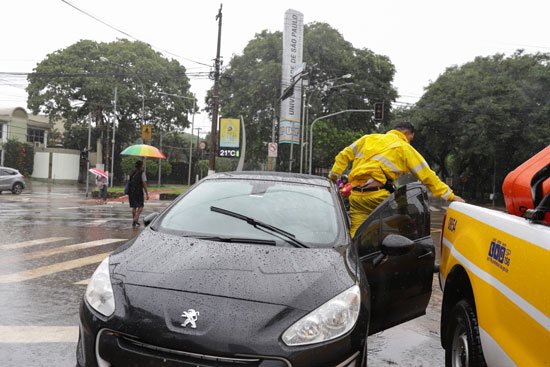 رجل يعمل على سيارة تالفة في شارع غمرته المياه بعد هطول أمطار غزيرة فى البرازيل