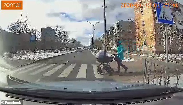 سيدة تعبر الطريق بعربة طفلها الرضيع