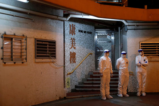 أفراد يرتدون ملابس واقية خلال عملية الاجلاء فى هونج كونج
