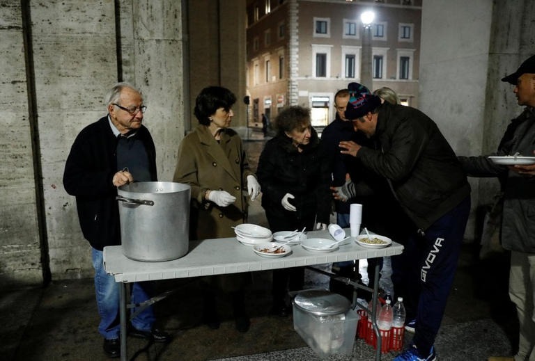 دينو إيمبالياتزو يوزع الطعام على الفقراء فى الشارع