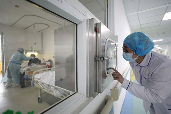 عامل طبي يستدعي زميله داخل جناح معزول في مستشفى جينتيان في ووهان