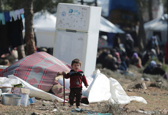 طفل نازح داخليًا يسير في مخيم مؤقت في قرية قطمة