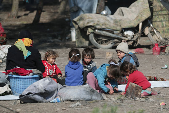 أطفال مشردون داخلياً يجلسون في مخيم مؤقت في قرية قطمة