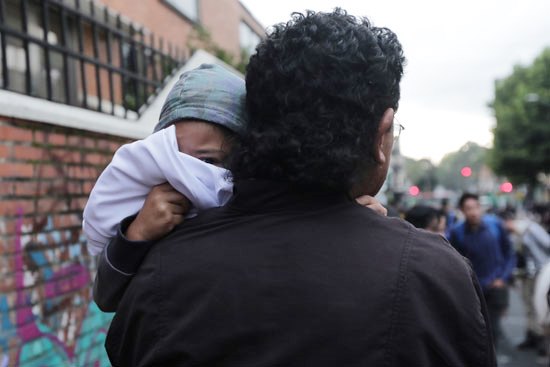 متظاهر يحمل طفله فى الميدان
