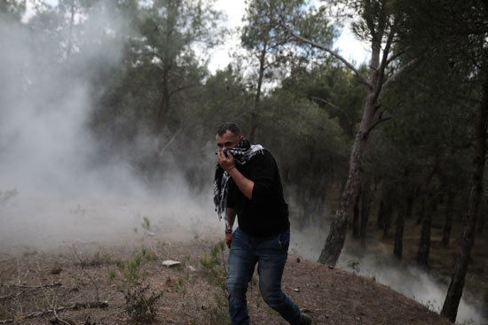 متظاهر يجرى من الغاز المسيل للدموع