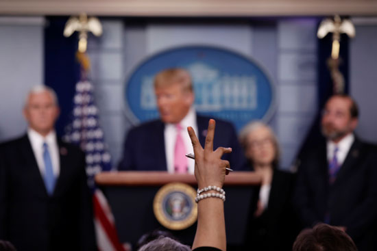 مراسلة ترفع يدها بينما يجيب الرئيس الأمريكي دونالد ترامب على سؤال خلال مؤتمر صحفي حول تفشي فيروس كورونا