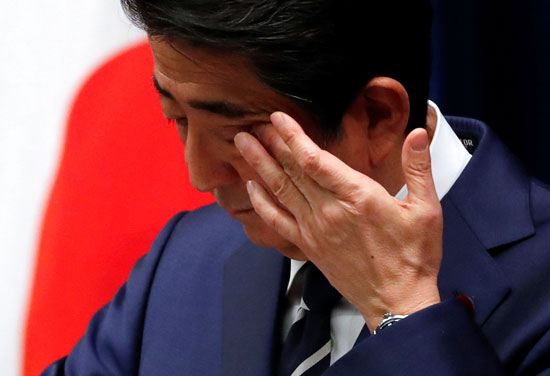 رئيس وزراء اليابان يمسح عيناه خلال المؤتمر الصحفى