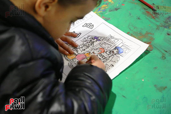 طفل يرسم فى ورش معرض الكتاب