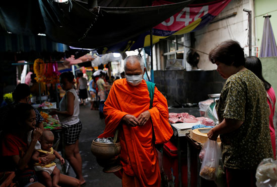 راهب بوذى يرتدى قناعا فى تايلاند خوفا من كورونا