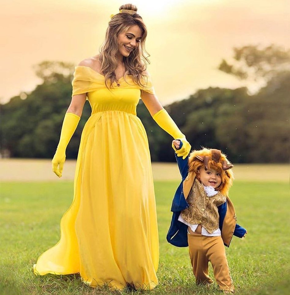 سيدة بفستان Princess Aurora مع ابنها بزى lion king
