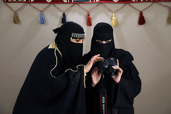 نساء سعوديات ينظرن إلى الصور المعروضة على شاشة الكاميرا خلال مهرجان طنطورة