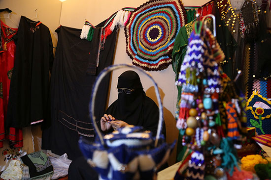 امرأة سعودية تجلس داخل متجرها خلال مهرجان طنطورة في بلدة العلا القديمة