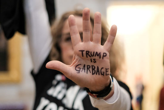 متظاهرة تكتب على يدها ترامب هو القمامة خلال تجمع حاشد يطالب بإقالة الرئيس ترامب في مبنى الكابيتول