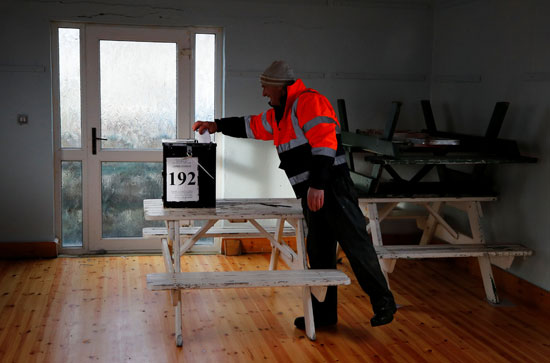 رجل يدلي بصوته في مركز اقتراع في جزيرة إنيشبوفين