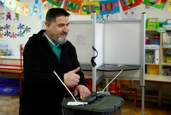 رجل يلمح وهو يدلي بصوته في الانتخابات الوطنية الأيرلندية في كورك