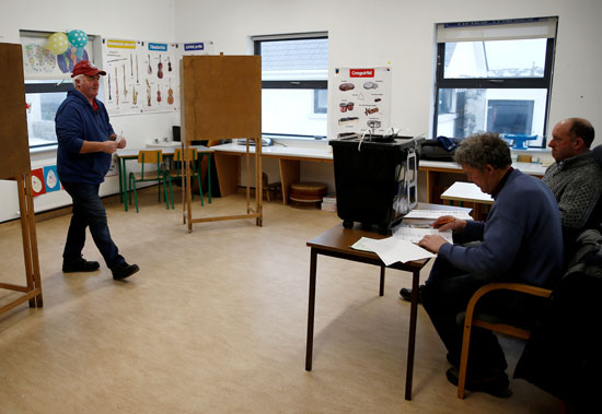 رجل يستعد للإدلاء بصوته في مركز اقتراع في إينيشير