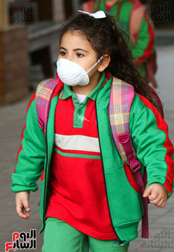 طفلة ترتدى الكمامة لتجنب نقل العدوى
