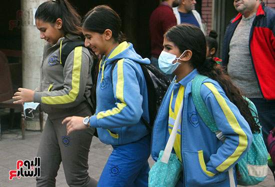 طالبة ترتدى الكمامة فى طريقها للمدرسة