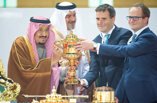 يحمل العاهل السعودي سلمان بن عبد العزيز الكأس للفائز وهو يحضر السباق النهائي لكأس السعودية
