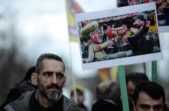 متظاهر يحمل لافتة خلال مظاهرة مناهضة لزيارة الرئيس التركي قرب ميدان شومان في بروكسل