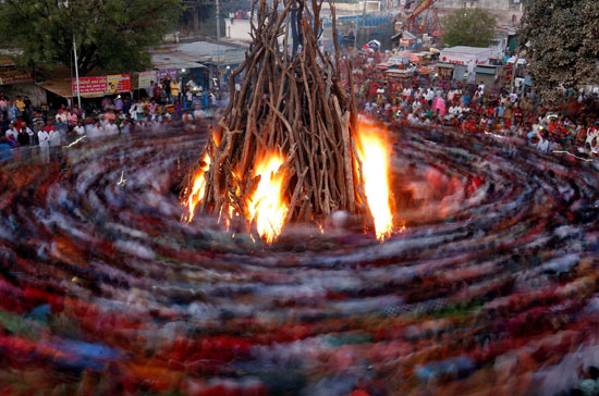 مصلون الهندوس يصنعون النار خلال طقوس تُعرف باسم هوليكا دهان والتي تعد جزءًا من احتفالات مهرجان هولي ، في أحمد آبا