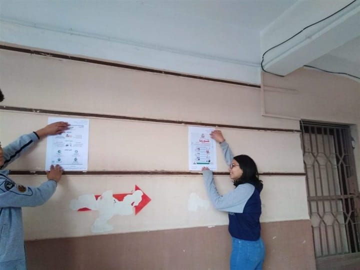 طلاب القاهرة يعلقون ملصقات للتوعية بكورونا (2)