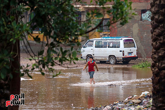 طفل يعبر مياه الامطار
