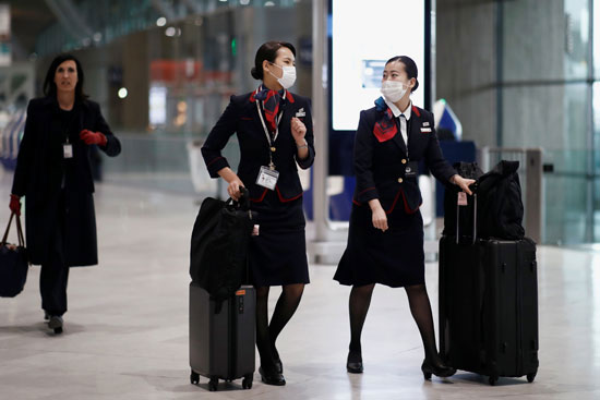 مضيفات الخطوط الجوية اليابانية يرتدين أقنعة الوجه فى مطار باريس شارل ديجول