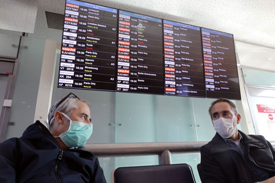 المسافرون الذين يرتدون أقنعة واقية فى انتظار رحلاتهم فى مطار نيس