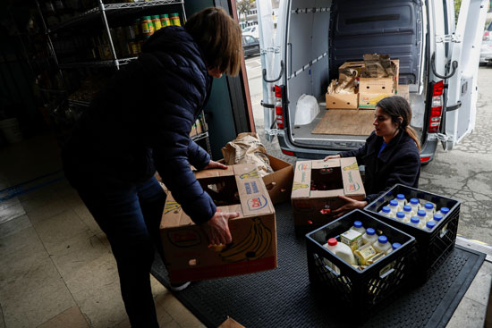 المديرة التنفيذية في بنك ألاميدا للأغذية ، والمتطوعة جوليا ويليامز تقوم بتحميل صناديق من الأغذية المتبرع بها على شاحنة صغيرة في بنك ألاميدا للأغذية