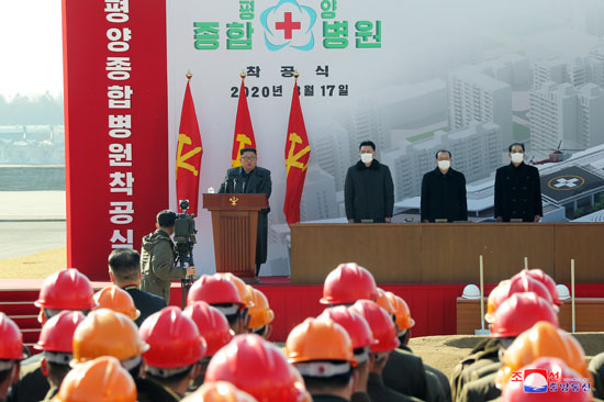 زعيم كوريا الشمالية يتحدث ومن بجواره يرتدى كمامات