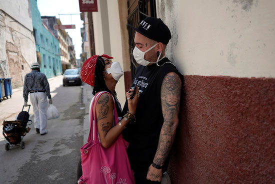 الفنانون فرناندو مارتينيز وإيريس لايديس يرتديان أقنعة حماية أثناء محادثتهما