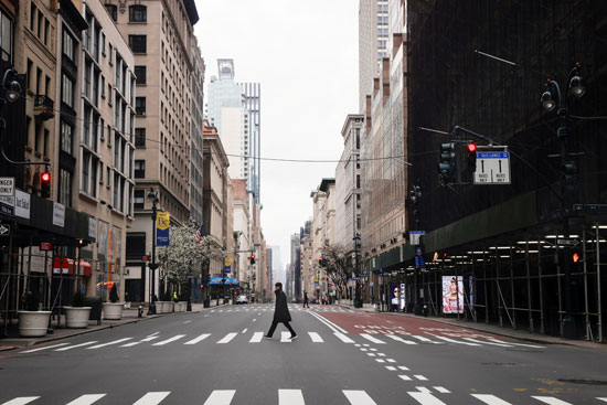 رجل-يعبر-شارعًا-خامسًا-تقريبًا-فارغًا-في-وسط-مدينة-مانهاتن-في-نيويورك