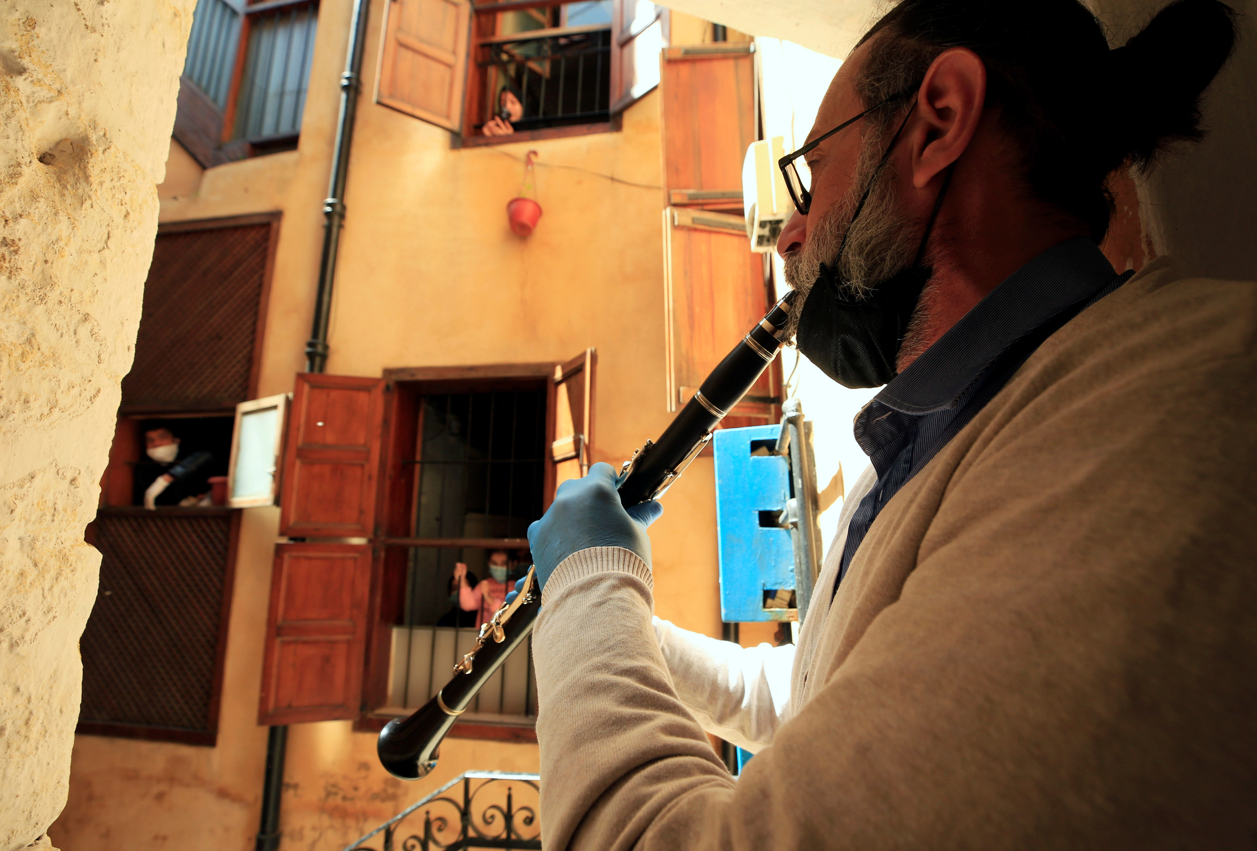طارق باشاشا ، فنان يبلغ من العمر 49 عامًا ، يعزف على الكلارينيت للترفيه عن الناس في منازلهم ، خلال إغلاق على مستوى الدولة جنوب لبنان