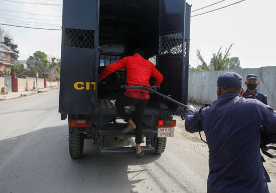 ضابط شرطة نيبالى يحافظ على المسافة حيث يحتجز رجلاً يتحدى الإغلاق الذي تفرضه الحكومة