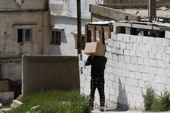 مواطن يحمل المساعدات الغذائية التى قدمها له الجيش الأردنى