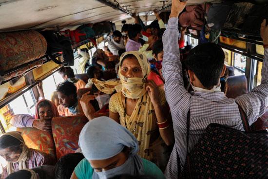 عمال مهاجرون في حافلة ولاية أوتار براديش لنقل خلال فترة إغلاق استمرت 21-يومًا بالهند