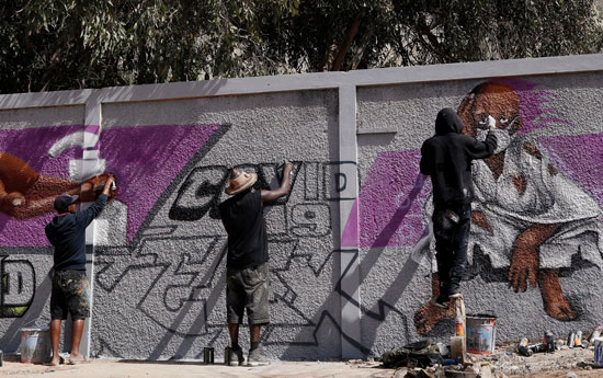 فنانو الجرافيتى يعمل على جدارياتهم لتشجيع الناس على حماية أنفسهم من فيروس كورونا