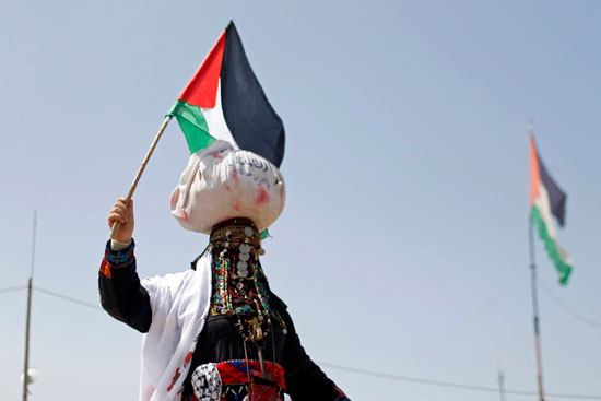 سيدة-فلسطينية-ترفع-علم-بلادها