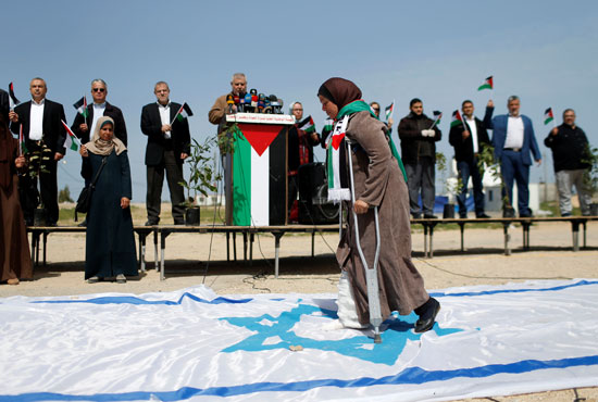 إمرأة-فلسطينية-تمر-على-علم-إسرائيل-خلال-فعالية-محدودة