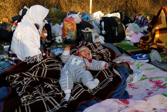 مهاجرون يستريحون بالقرب من معبر بازاركولي الحدودي التركية