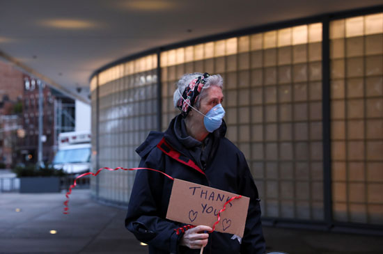 مواطن يحمل لافتة شكر للطواقم الطبية فى نيويورك على مجهودهم فى مكافحة كورونا