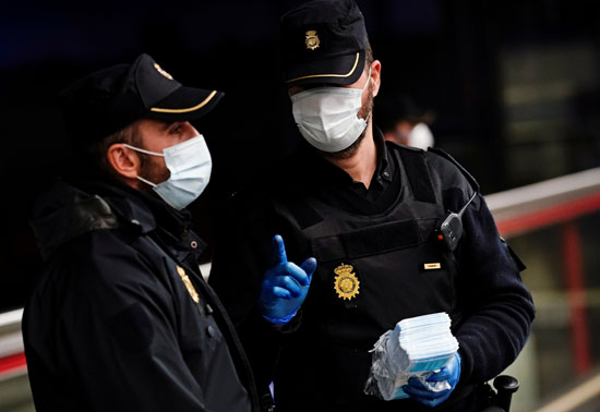ضباط شرطة مدريد يحملون كمامات لتوزيعها مجانا