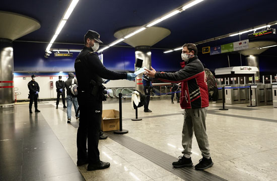ضابط أسبانى يوزع كمامات مجانية بمترو مدريد