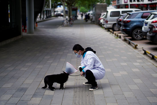 احد سكان ووهان الصينية يلاعب كلب