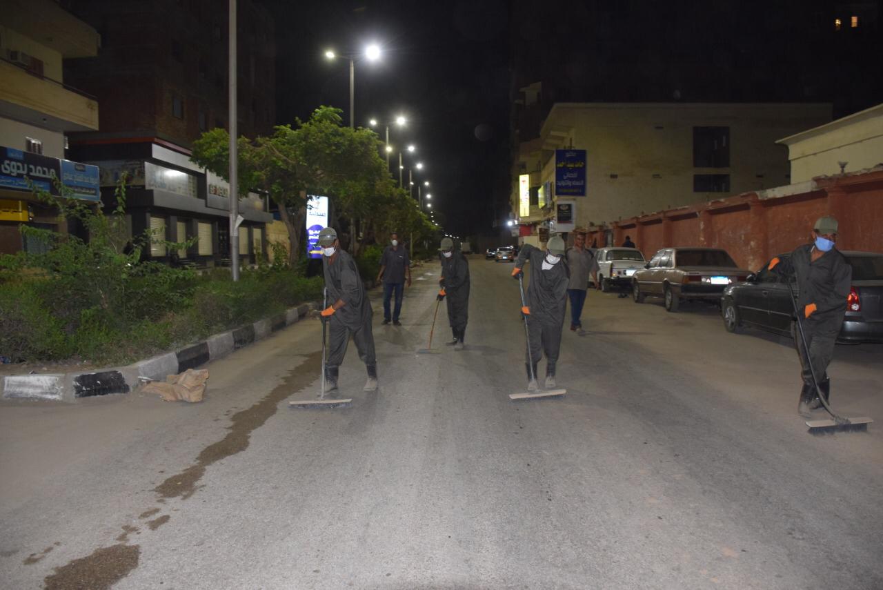 رجال النظافة خلال تجميل الشوارع ليلاً بالأقصر
