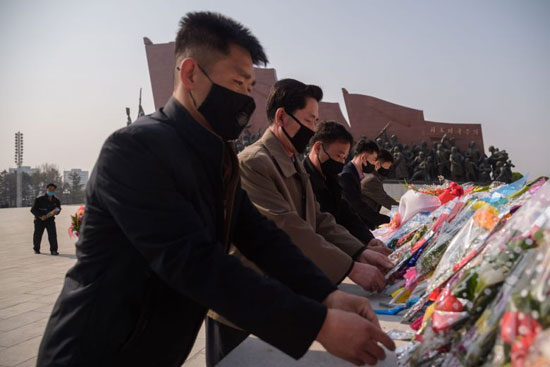 مواطنون يردتون الكمامات فى احتفالية ميلاد مؤسس كوريا الشمالية
